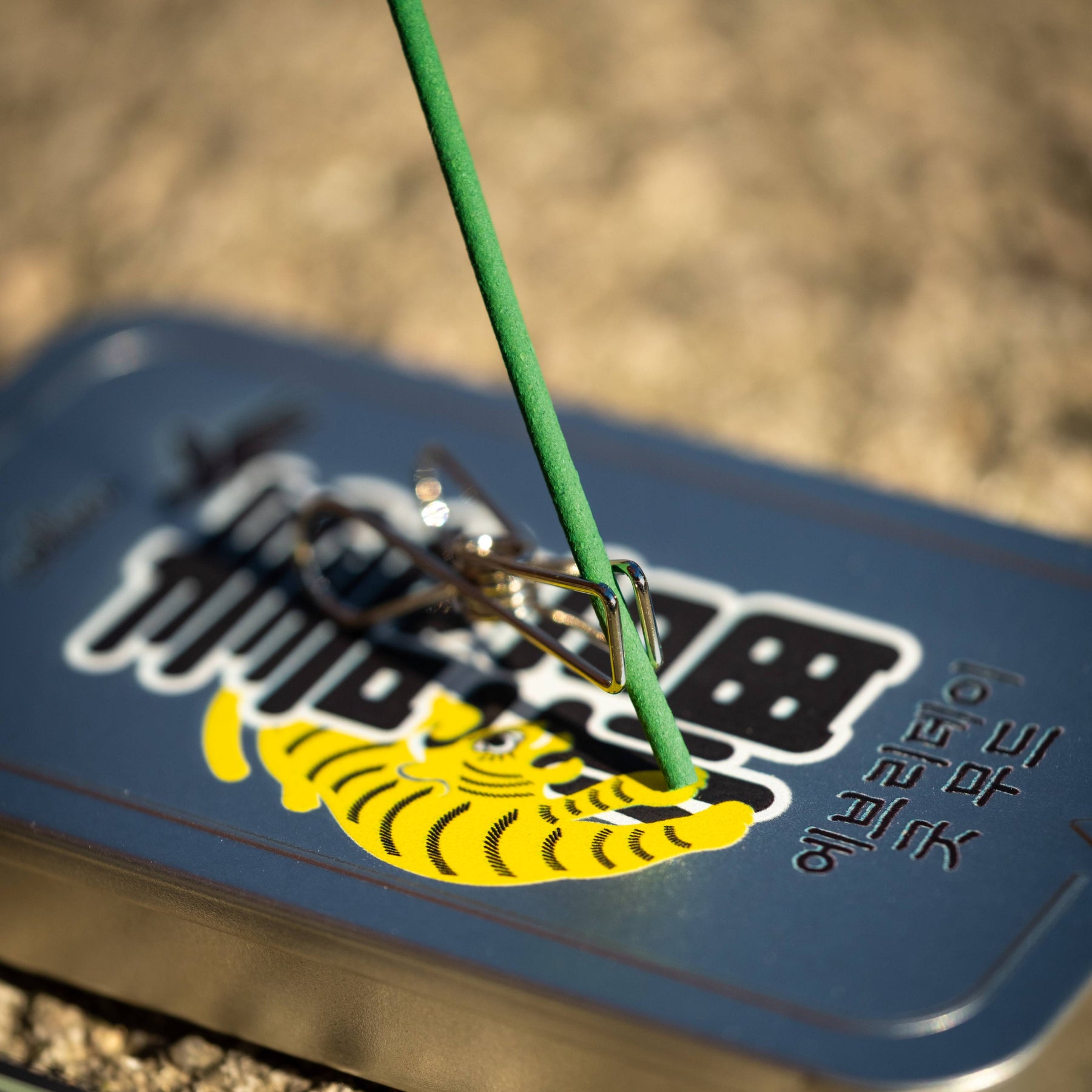 Incense being held by clip on incense tin