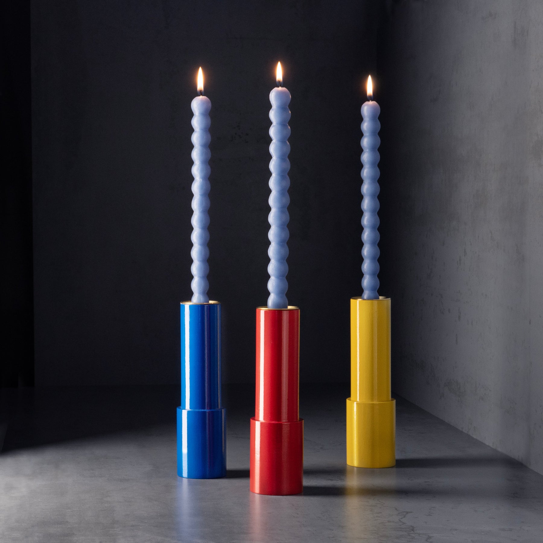 Selection of Sophie Taeuber Arp Candle sticks with blue candles