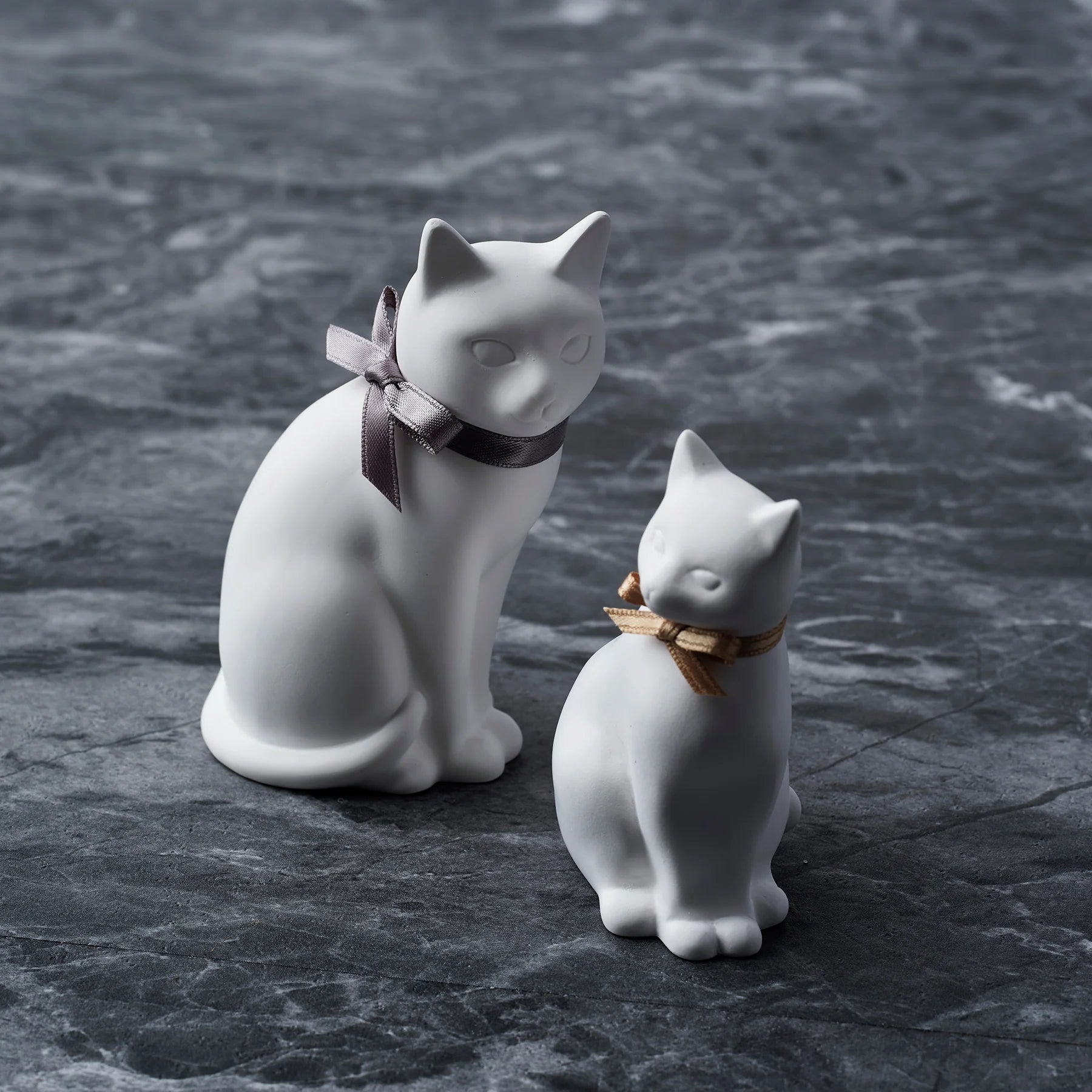2 Plaster Cats Aroma Ornaments on Marble Surface