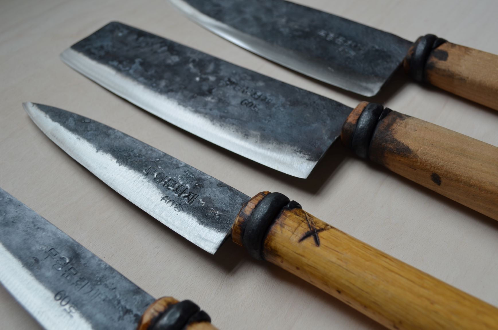 Master Shin's Anvil, detail photo of group shot of 4 knives