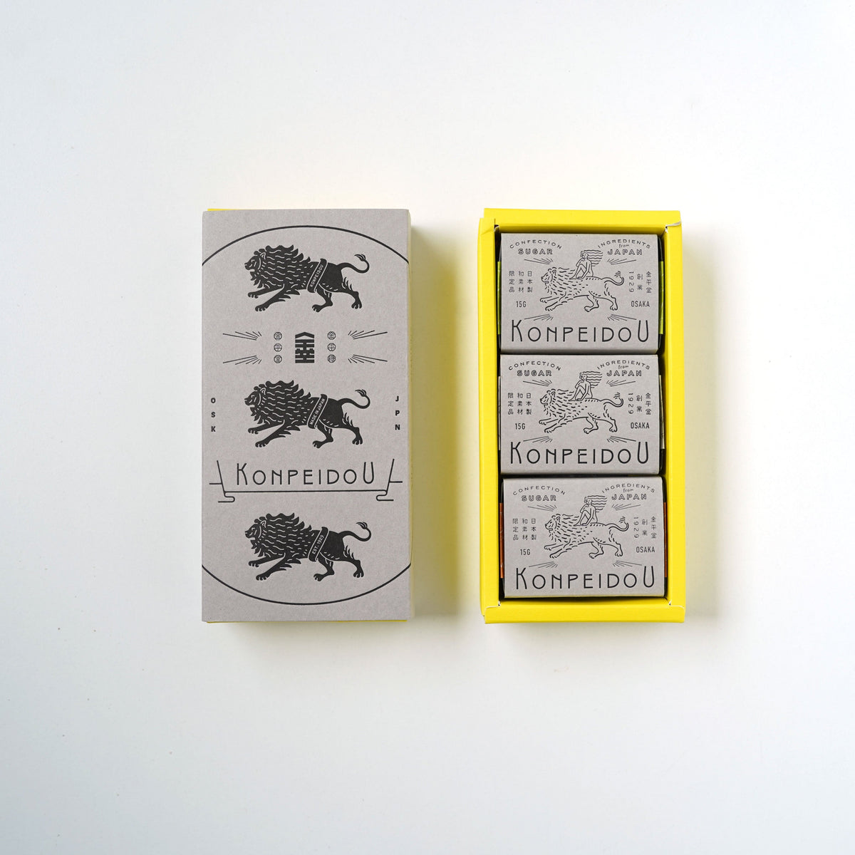 A set of three matchboxes from the brand KOMPEIDOU, displayed on a clean white background. The set includes one closed matchbox with a gray cover featuring a black illustration of a lion and the brand name, and an open yellow tray containing three individual matchboxes with gray covers.