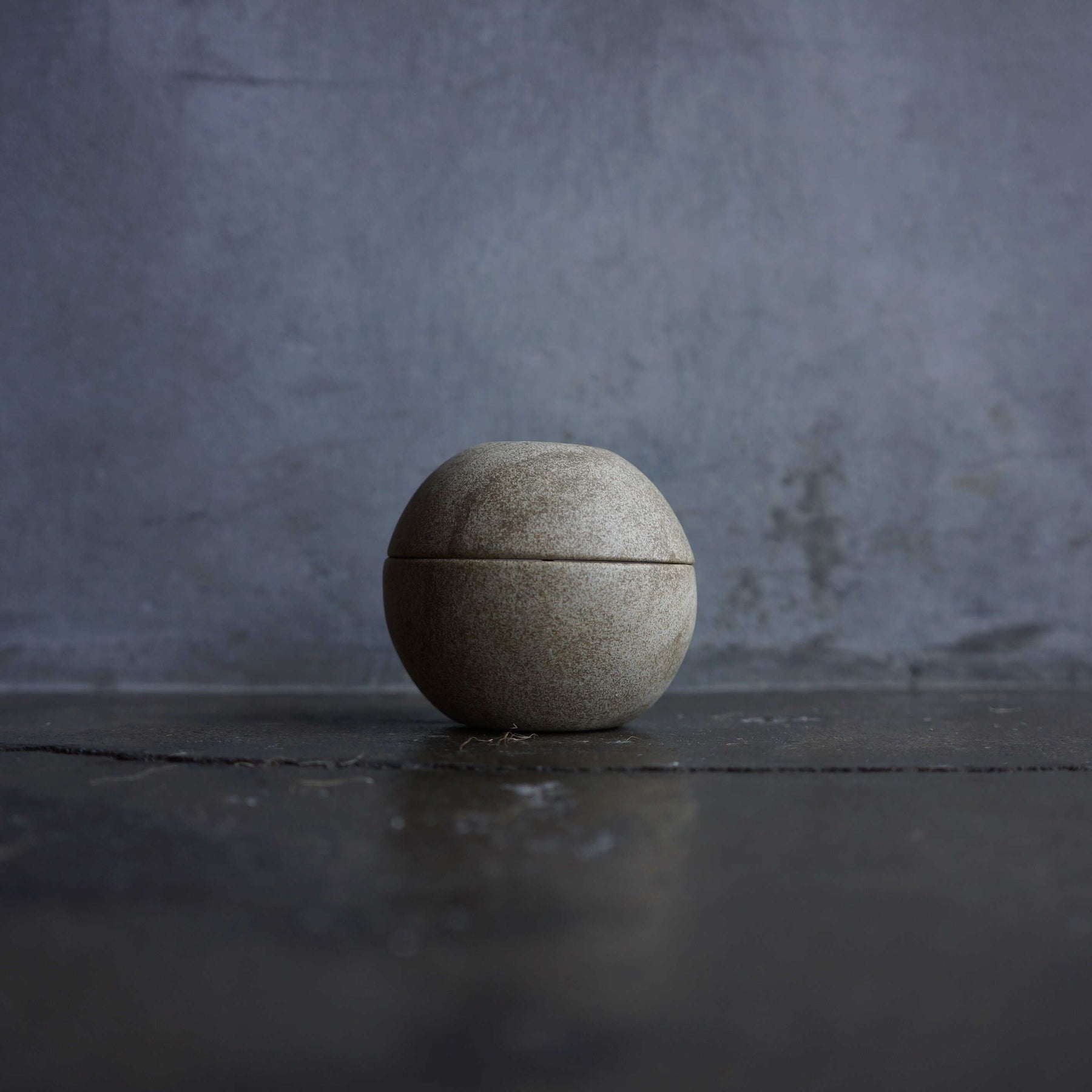 Ceramic container on a dark surface with a gray textured background
