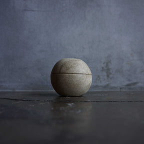 Ceramic container on a dark surface with a gray textured background