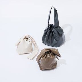 Three fabric bags in beige, gray, and brown on a white background