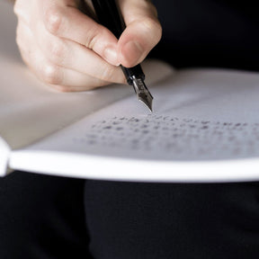 Hand writing with a fountain pen on a notebook